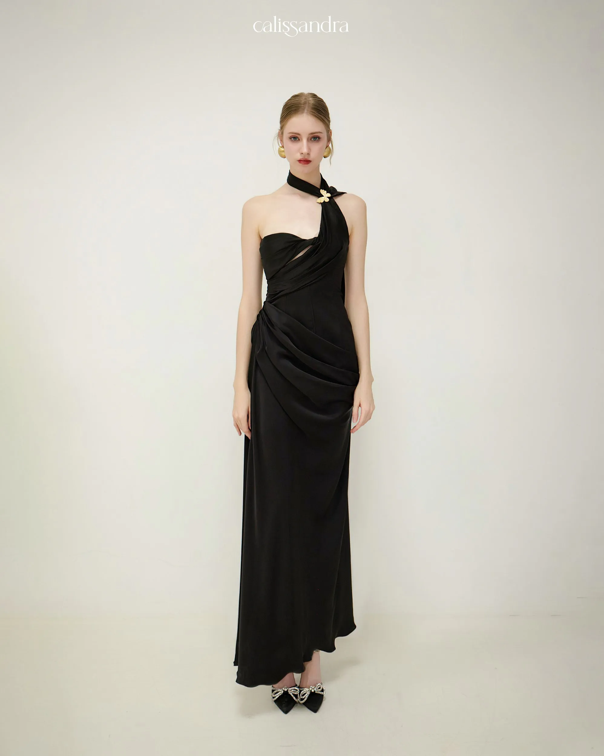 Full-length front view of Adalicia white one-shoulder maxi dress with exquisite draping detail on the bodice and skirt by Calissandra