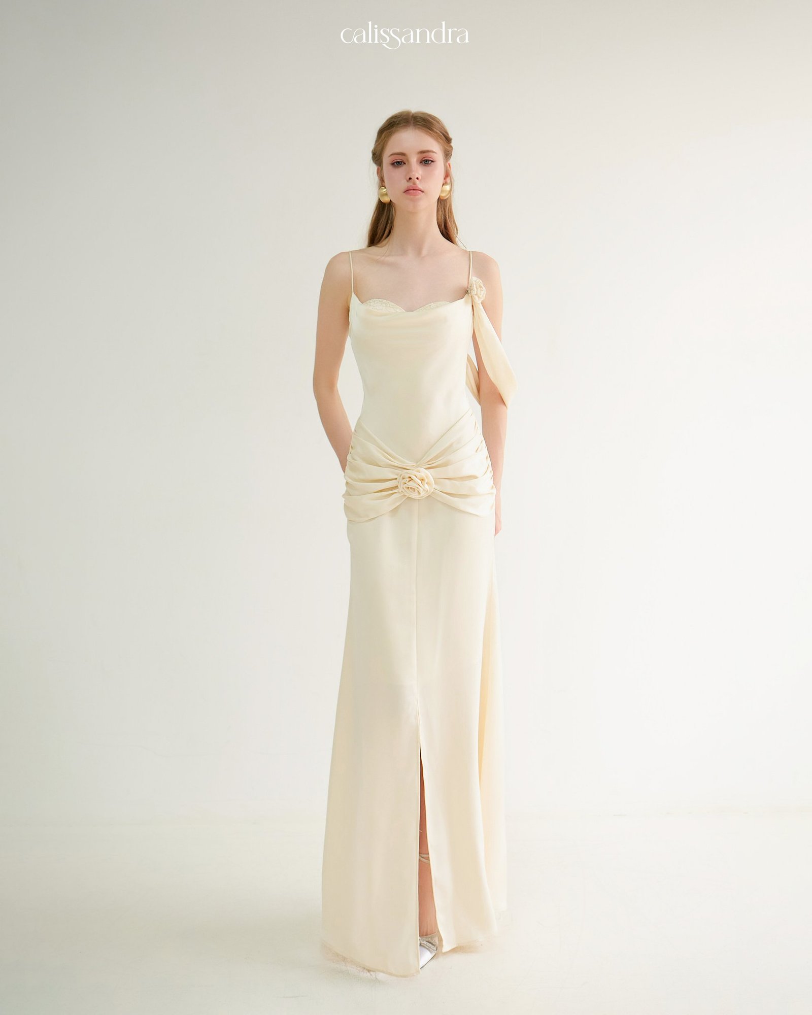 Close-up front view of Auriane cream silk gown featuring delicate 3D fabric rose details on the shoulder and draped lower waist by Calissandra
