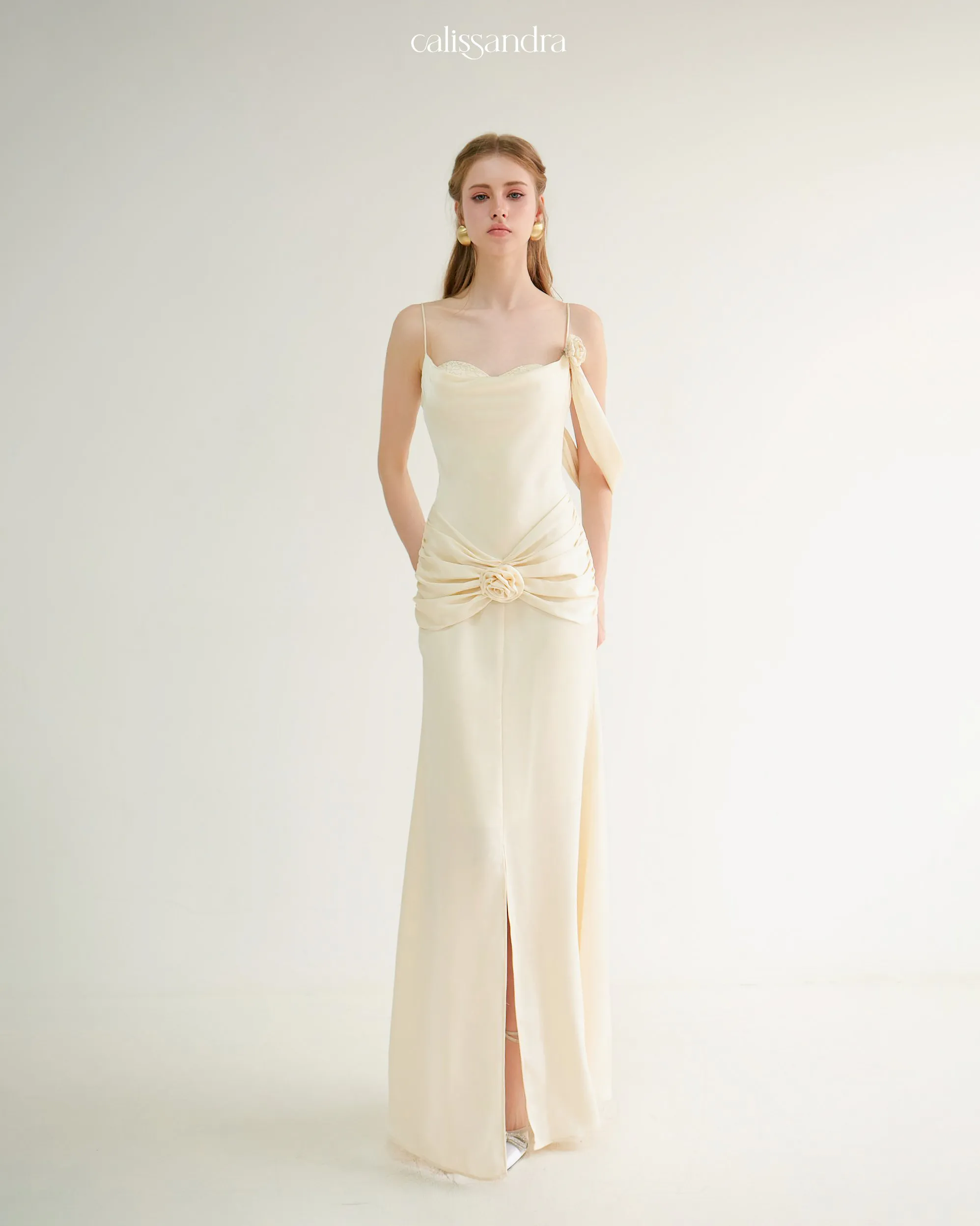 Close-up front view of Auriane cream silk gown featuring delicate 3D fabric rose details on the shoulder and draped lower waist by Calissandra