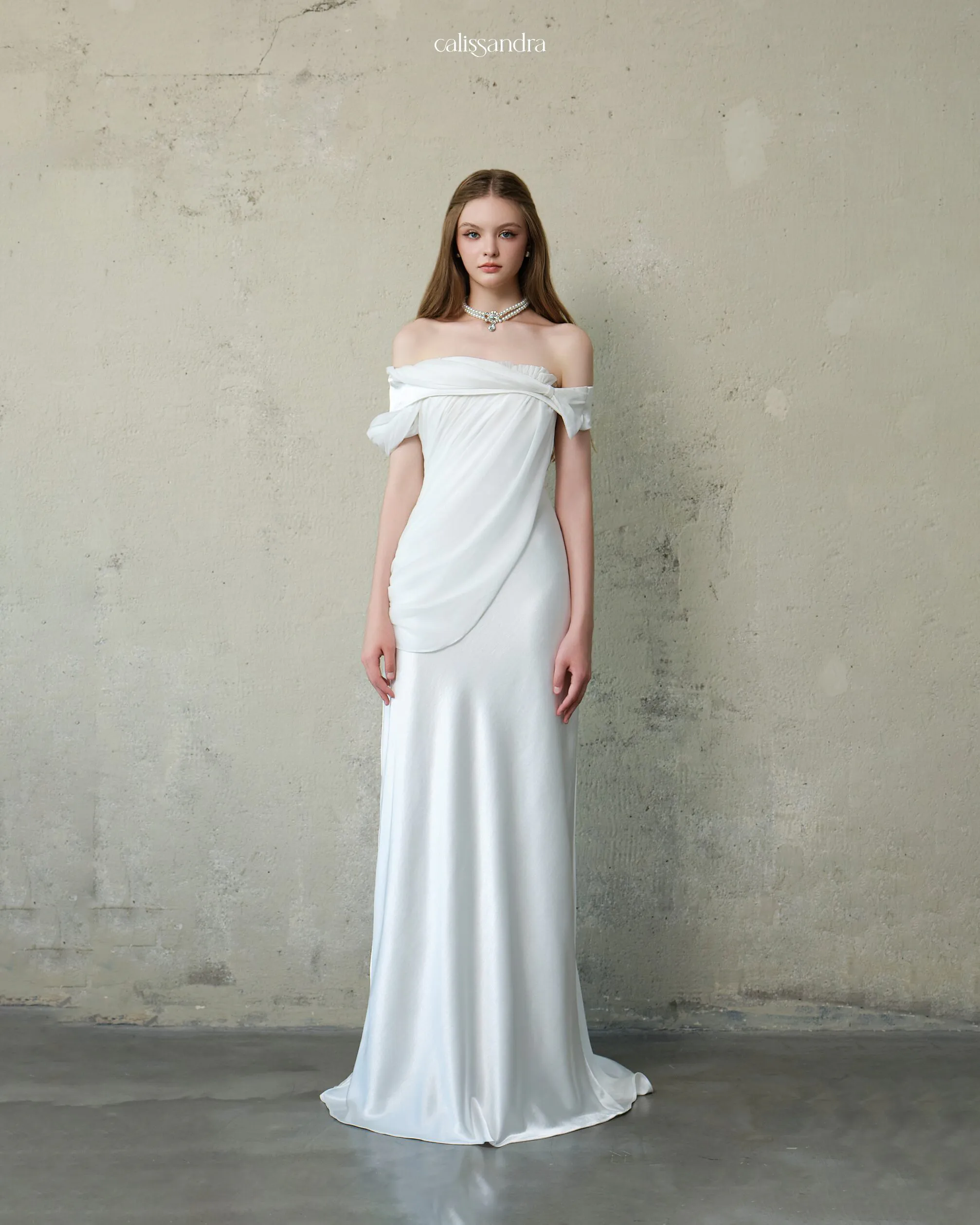 Full-length view of Diamelle luxury ivory white silk satin formal evening dress, featuring an off-the-shoulder neckline with a soft asymmetrical draped chiffon overlay by Calissandra