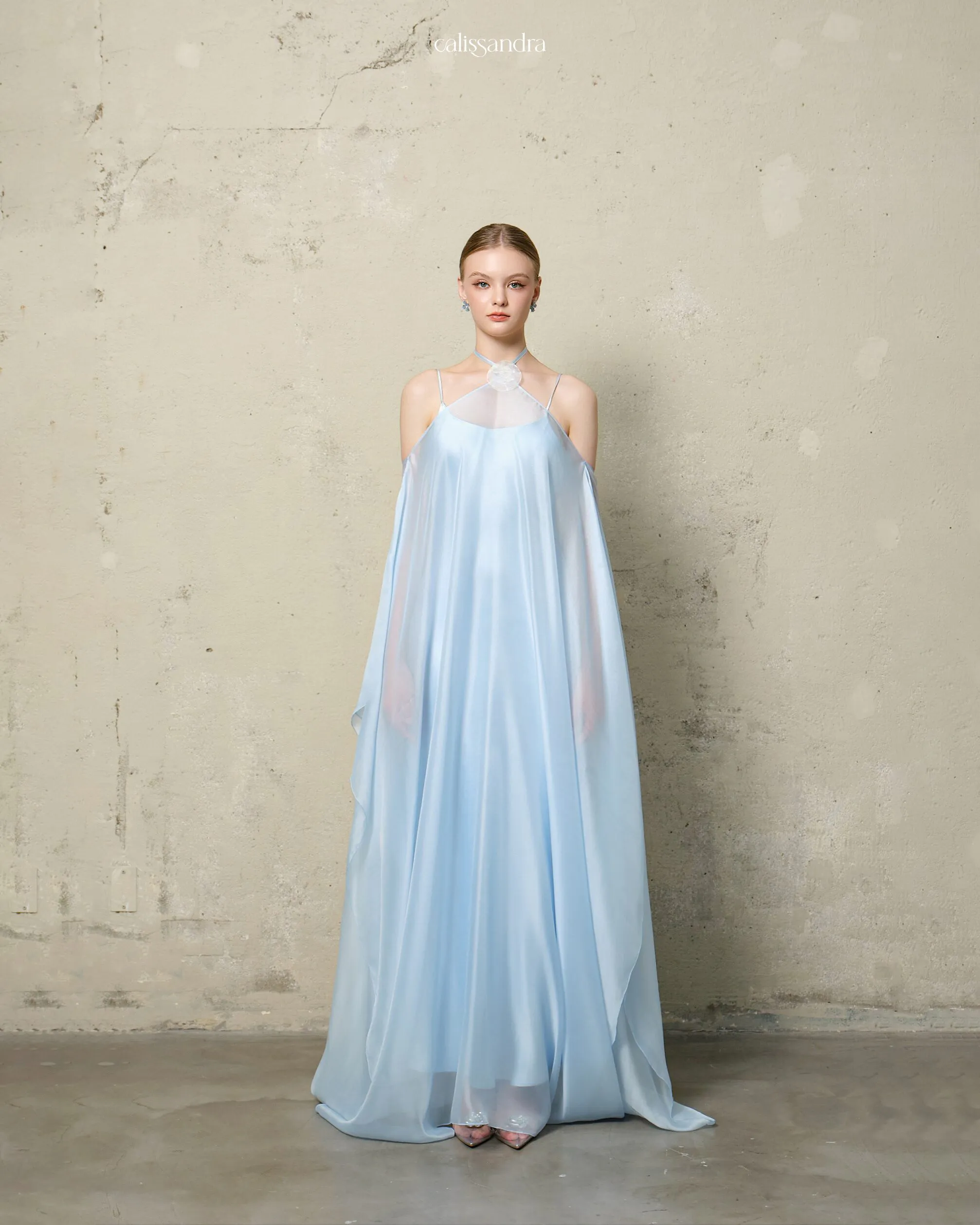 Full-length view of Saphielle luxury baby blue silk satin gown with a sheer flowing chiffon cape overlay, detailed with a striking 3D floral choker by Calissandra