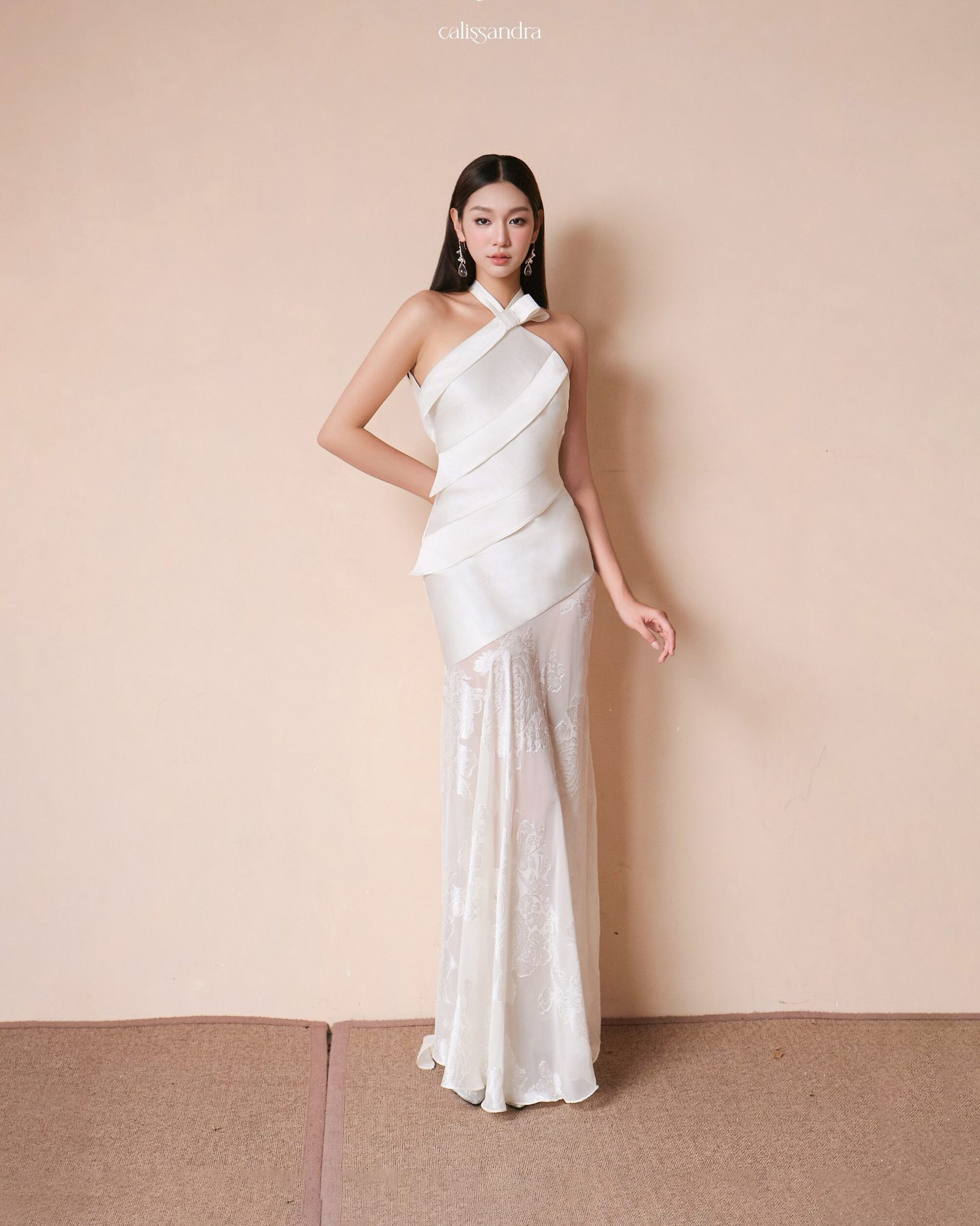 Full-length front pose view of Peonelle ivory white halter maxi dress showcasing the elegant hourglass silhouette and structured draped bodice by Calissandra