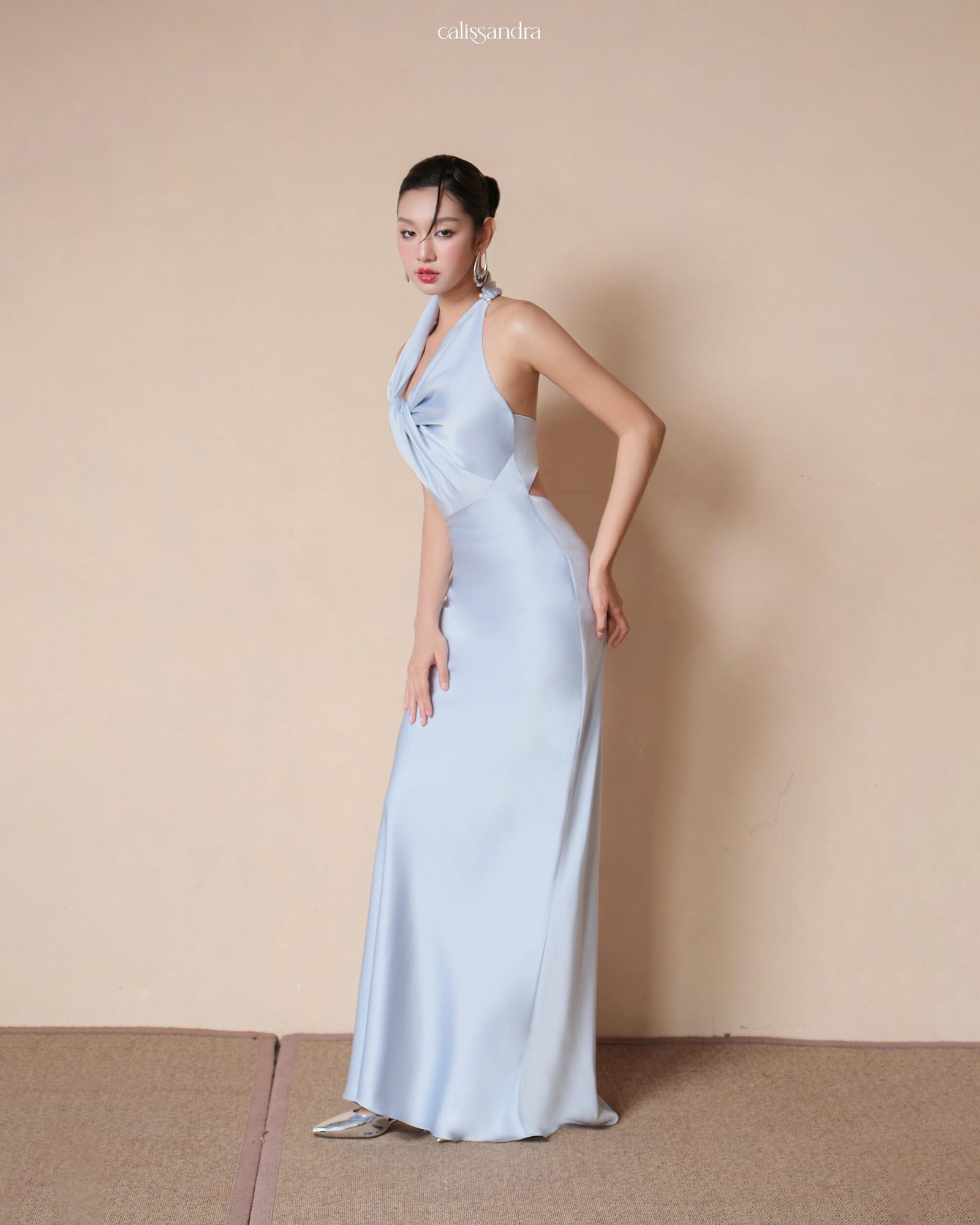 Model wearing the Calissandra Lunaria Ice Blue Asymmetrical Twisted Silk Dress, front view