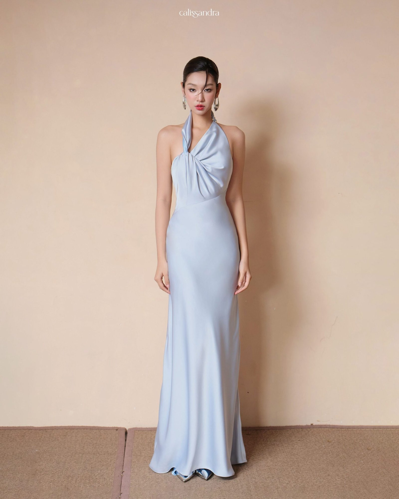 Model wearing the Calissandra Lunaria Ice Blue Asymmetrical Twisted Silk Dress, front view