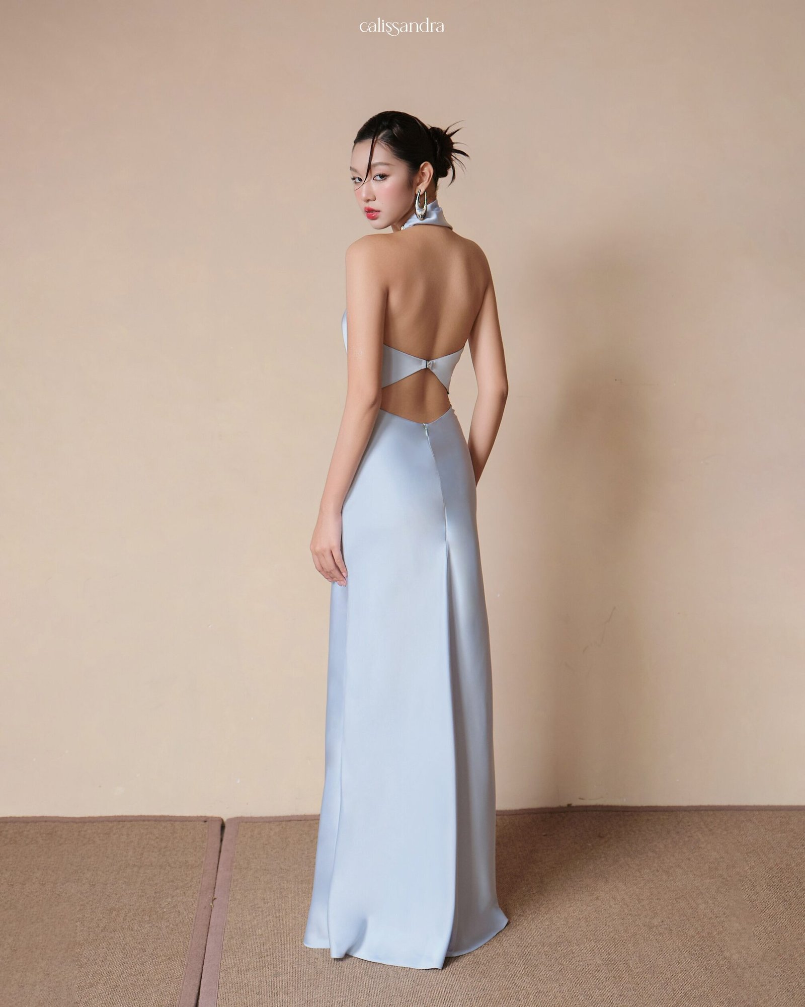 Model wearing the Calissandra Lunaria Ice Blue Asymmetrical Twisted Silk Dress, front view